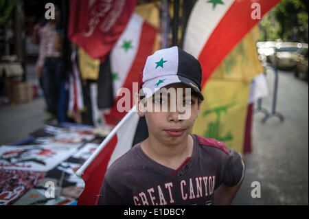 Damasco, Siria. 31 Maggio, 2014. Un ragazzo siriano pone di fronte a una fase di stallo che vendono souvenir in Damasco Capitale della Siria, il 31 maggio 2014, in vista delle prossime elezioni presidenziali del 3 giugno. Credito: Pan Chaoyue/Xinhua/Alamy Live News Foto Stock