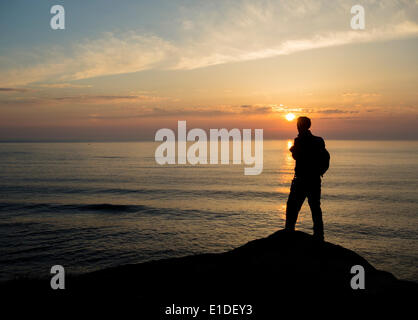 Walker al naso del punto vicino a Seaham all alba del patrimonio di Durham coast sentiero. Contea di Durham, England, Regno Unito Foto Stock