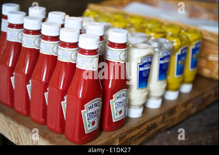 Gruppo di salse su un tavolo in un ristorante - più bottiglie di ketchup, maionese e senape Foto Stock