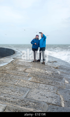 Giovane prendendo un selfie sul Cobb, Lyme Regis, Dorset, England, Regno Unito Foto Stock