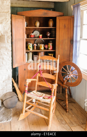 La sedia a dondolo e ruota che gira all'interno di una vecchia casa Foto Stock