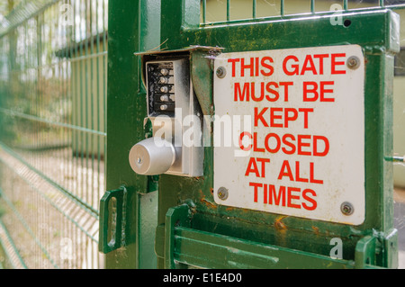 Segno su un cancello di sicurezza che avverte che esso deve essere mantenuto chiuso. Foto Stock