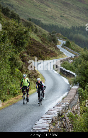 Coppia di ciclisti cavalcare un percorso attraverso la campagna sull'Isola di Skye Foto Stock