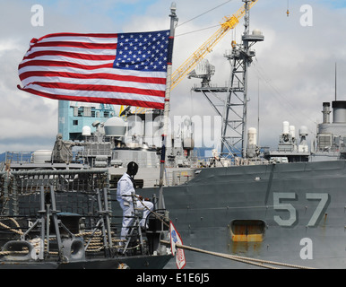 Un U.S. Sailor sorge guarda a bordo guidato-missile fregata USS Crommelin (FFG 37) come la nave si prepara a scendere in modo da Foto Stock