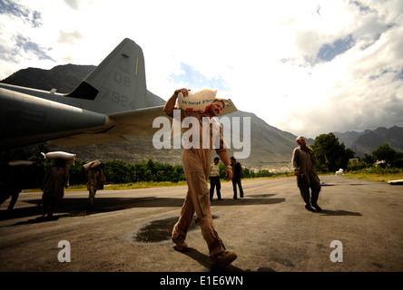 Un U.S. Marine porta un sacco di farina da un KC-130J Super Hercules aeromobile assegnati alla antenna Marine Refueler Squadr di trasporto Foto Stock