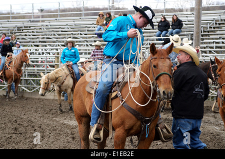 Alta scuola rodeo concorrente prende la sua posizione nel sistema di funi di vitello. Foto Stock