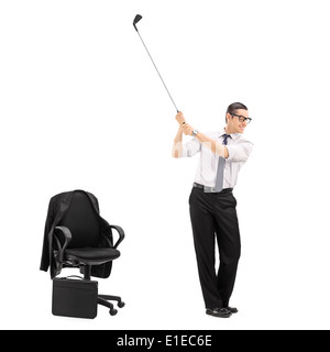 Imprenditore oscillazione un golf club con una sedia da ufficio accanto a lui Foto Stock