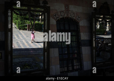 (140602) -- Damasco, 2 giugno, 2014 (Xinhua) -- una ragazza siriana passeggiate da uno specchio a Azem Palace di Damasco Capitale della Siria, il 1 giugno 2014, prima delle elezioni presidenziali del 3 giugno. (Xinhua/Pan Chaoyue) Foto Stock