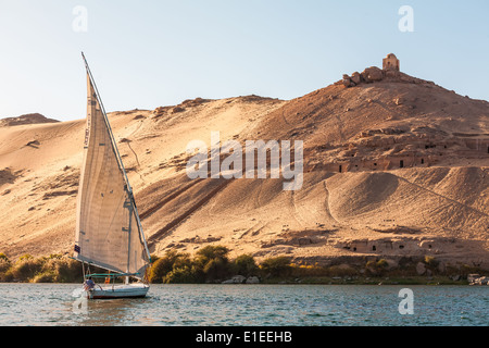 Faluka barca a vela vela sul fiume Nilo con moschea abbandonata, Aswan, Egitto Foto Stock