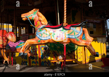 Un vecchio stile cavalli al galoppo fairground ride nel parco di divertimenti a Hunstanton, Norfolk. Foto Stock