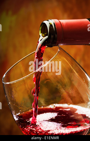 Il vino rosso è versata nel bicchiere di vino Foto Stock