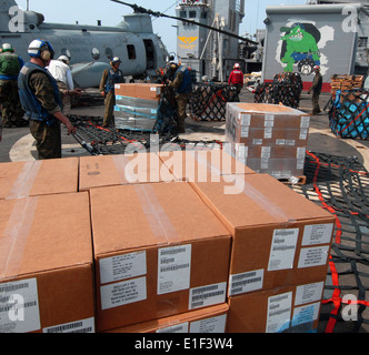 Il personale assegnato per il trasporto anfibio dock nave USS Dubuque (LPD 8) combattere Cargo plotone avvolgere un pallet di aiuti umanitari Foto Stock