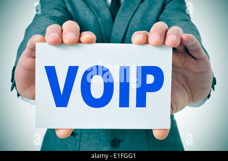 L uomo indossa una tuta tenendo un cartello con scritto il testo VOIP, Voice Over Internet Protocol, scritto in esso Foto Stock
