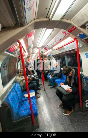 Persone su un treno della metropolitana di Londra, in Inghilterra, Regno Unito Foto Stock