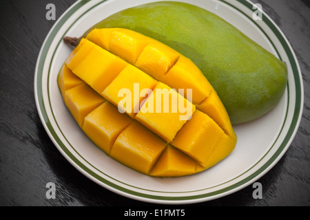 Giallo i cubetti di mango tagliati a fette sulla piastra bianca Foto Stock