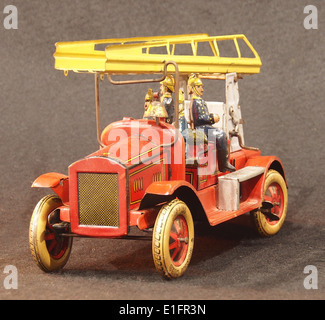 Il camion del fuoco giocattolo in stagno è un veicolo da collezione vintage, progettato per il gioco dei bambini e realizzato in stagno, che rappresenta le storiche tecniche di produzione dei giocattoli. Foto Stock