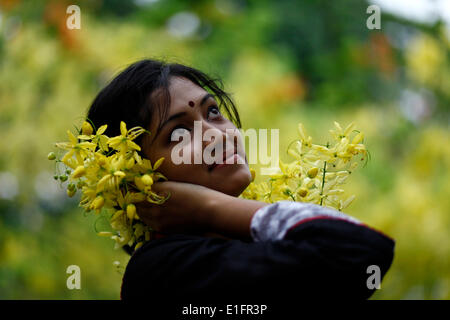 Dacca,Bangladesh 05 maggio 2014; le ragazze del Bangladesh godendo con fiori estivi nella stagione estiva.Durante la stagione estiva di molti tipi di fiori fioriscono denominato Krishnachura (Delonix regia),Sonalu Fiore (Cassia fistola),Palissandro Moulmein (Millettia Peguensis),Tropical mirto di crespo (Lagerstroemia Trubinata) ecc. Foto Stock