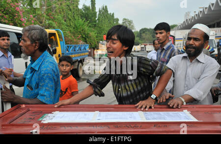 Dacca, Arabia Saudita. 13 Maggio, 2014. Un parente di una vittima grida al di sopra di una bara dopo i corpi dei migranti del Bangladesh sono arrivati a Hazrat Shahjalal International Airport dall Arabia Saudita a Dhaka, nel Bangladesh, 3 giugno 2014. Almeno nove cittadini del Bangladesh sono stati uccisi in un incidente di fuoco ad una fabbricazione di mobili fabbrica in Riyadh, la capitale dell'Arabia Saudita, 13 maggio 2014. © Shariful Islam/Xinhua/Alamy Live News Foto Stock