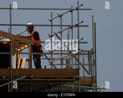 Workman lavorando sul tetto di nuovi appartamenti in costruzione Condino, Devon, Regno Unito Foto Stock