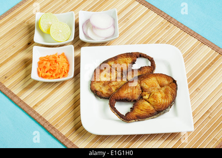 Delizioso, coperti fritto, veggente incrostato/sgombro filetti di pesce serviti con carote grattugiate, materie anelli di cipolla e limone. Foto Stock