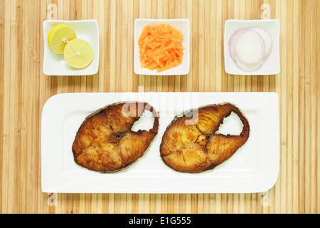 Vista superiore della deliziosa, coperti fritto, veggente incrostato/sgombro filetti di pesce serviti con carote grattugiate, materie anelli di cipolla e limone Foto Stock