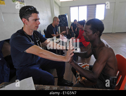 Stati Uniti Coast Guard tenente j.g. Jeff McCroskey, sinistra, un assistente medico imbarcato a bordo dell'assalto anfibio nave USS Iwo Jima Foto Stock