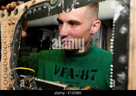 Stati Uniti Aviazione Navale meccanico strutturale Airman Maclon H. Poorman, assegnato a Strike Fighter Squadron (VFA) 87, ispeziona un pannello Foto Stock