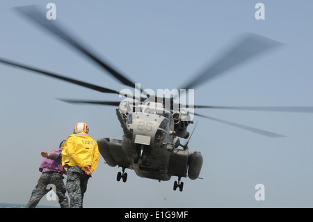 Stati Uniti Segnale di marinai da trasporto anfibio dock USS Denver (LPD 9) ad un MH-53E mare Dragon elicottero mentre sotto il modo in Foto Stock