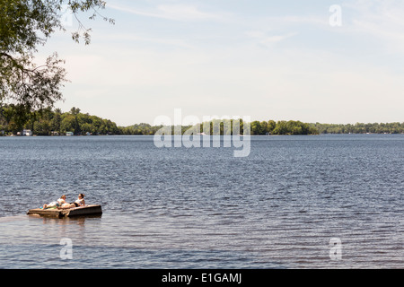 Vista sul lago di Cameron in Fenelon Falls Ontario mentre due donne sole su un calcestruzzo flottante dock. Foto Stock