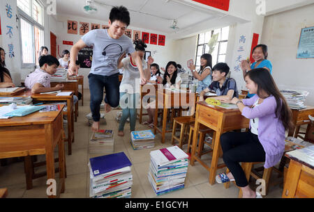 (140604) -- JINJIANG, Giugno 4, 2014 (Xinhua) -- "migranti studenti" o i figli dei lavoratori migranti prendere un periodo di riposo durante una pausa al Jingshan sui lavoratori migranti scuola bambini in Jinjiang City, a sud-est della Cina di provincia del Fujian, 3 giugno 2014. Un totale di 78 "migranti degli allievi della scuola avrà l'esame in Jinjiang, senza dover tornare alla loro patrie dove la loro registrazione per uso domestico è registrato. La provincia del Fujian questo anno avrà 3.600 "migranti studenti' sedere il collegio nazionale esame di ammissione, noto anche come "gaokao,' che è visto da molti genitori come un modo importante di ch Foto Stock