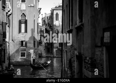 Gondoliere tenendo i turisti su una gondola in qualche piccolo canale di Venezia Foto Stock