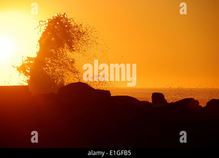 Onde al tramonto contro il molo sud del Rogue River vicino alla spiaggia di oro o Foto Stock