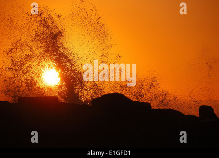 Onde al tramonto contro il molo sud del Rogue River vicino alla spiaggia di oro o Foto Stock