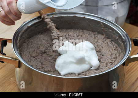 In cucina polacca, sulla tabella polacca. Preparazione di patè di fegato. Sull'immagine aggiunta di proteina da uova di gallina. Foto Stock