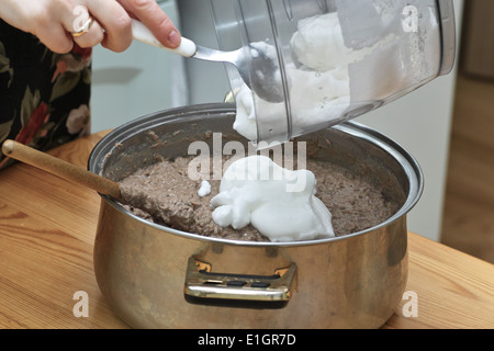 In cucina polacca, sulla tabella polacca. Preparazione di patè di fegato. Sull'immagine aggiunta di proteina da uova di gallina. Foto Stock