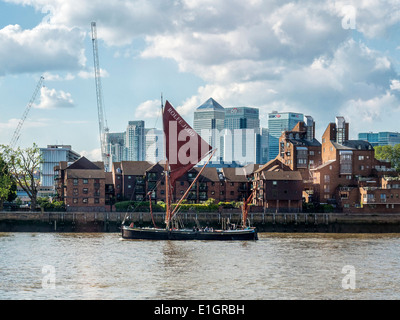 Il Ardwina chiatta a vela di proprietà di Rolfe Judd vele passato Canary Wharf distretto finanziario sul fiume Tamigi, Londra Foto Stock