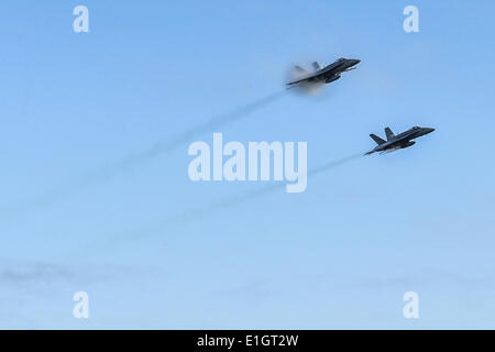 Due Marine Corps F/A-18 calabroni fighter aircraft rompere la velocità del suono creando un cono di shock che svolgono per gli ospiti che visitano la portaerei USS Ronald Reagan June 2, 2014 al largo della costa di Santa Barbara in California. Foto Stock