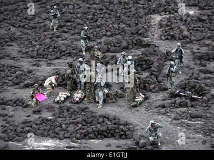 Stati Uniti Air Force pararescuemen, Esercito sito sicurezza dei membri del team e vittime di un aereo simulato crash attendono l arrivo di un Foto Stock