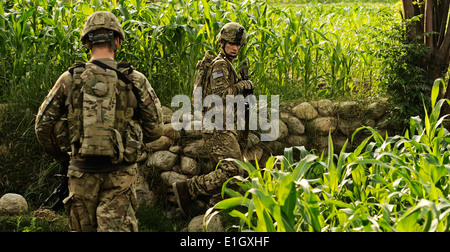 Stati Uniti Esercito Spcs. Kyle Graves (destra) e Michael Bartolo navigare attraverso le risaie e campi di mais mentre su una pattuglia di combattimento Foto Stock