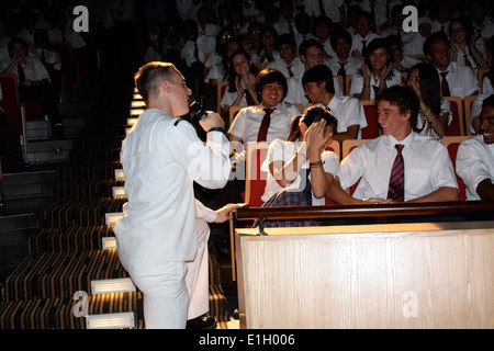 Stati Uniti Navy musicista di terza classe Gabriel marrone con la flotta di 7 band di Orient Express, canta per uno studente durante una performance di un Foto Stock