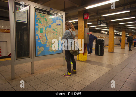 Un viaggiatore escogita il suo percorso in una mappa nella quattordicesima strada dalla stazione di metropolitana di New York di sabato 14 maggio, 2014. Foto Stock