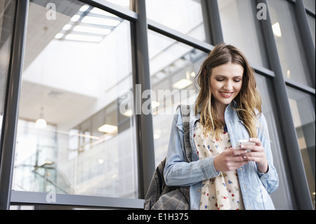 Giovane donna tramite telefono cellulare Foto Stock