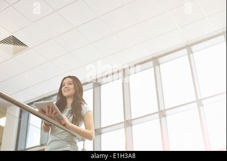 Giovane donna azienda digitale compressa, angolo basso Foto Stock