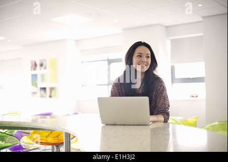 Giovane donna utilizzando laptop Foto Stock