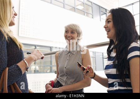 Giovani donne utilizzando i telefoni cellulari Foto Stock