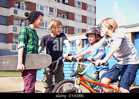 Un gruppo di ragazzi a parlare con le biciclette e skateboard Foto Stock