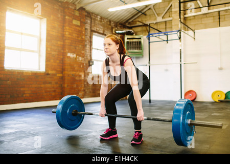 Sollevamento donna barbell in palestra Foto Stock