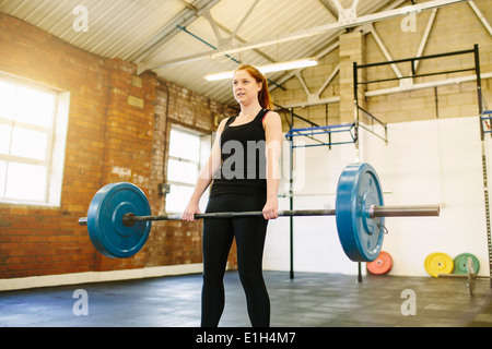 Sollevamento donna barbell in palestra Foto Stock