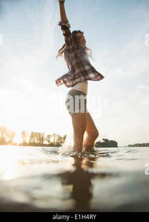 Giovane donna sguazzare nel lago Foto Stock