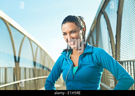 Metà donna adulta di indossare abbigliamento sportivo in piedi sul ponte Foto Stock